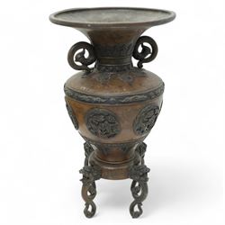 Late 19th/ early 20th century Japanese bronze Usubata vase, the flared top over two Phoenix cast handles, the ovoid body decorated in relief with mythical creatures within roundels, on four open mouth lion mask and scroll supports, H43cm x W24cm 