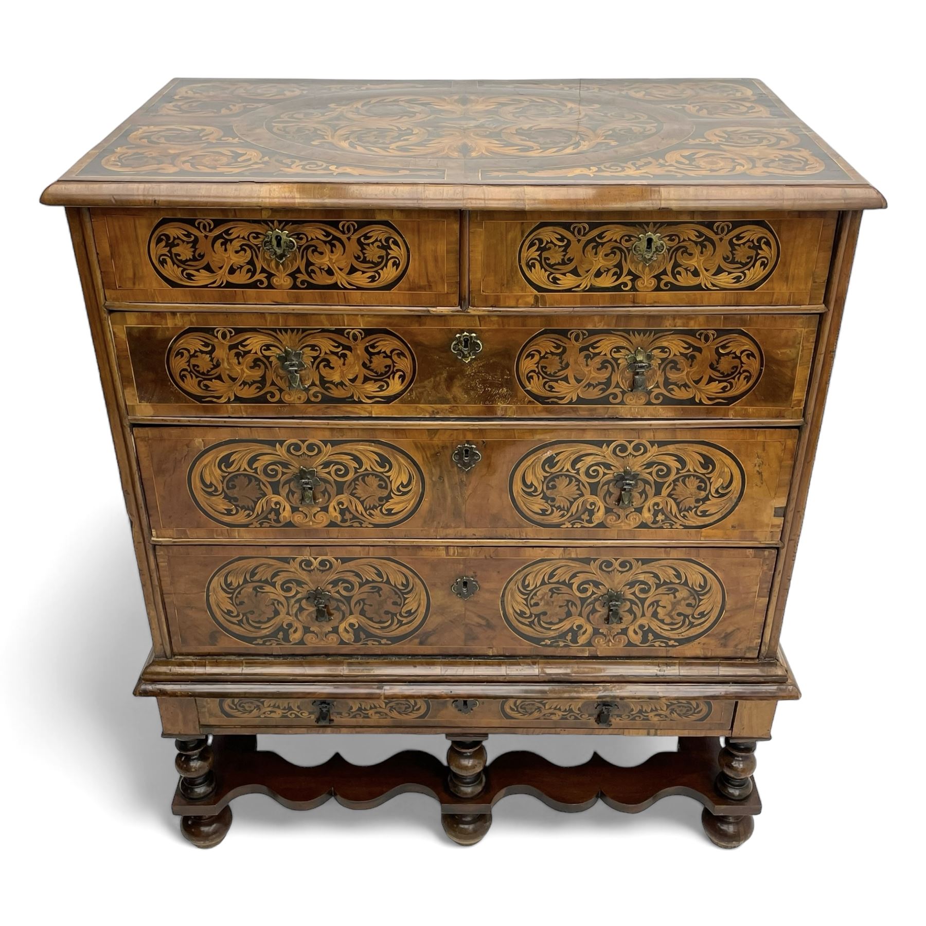 18th century inlaid walnut chest on stand, ovolo-moulded rectangular top inlaid with ebony panels each decorated with scrolling foliage, flower heads and birds, fitted with two short over three long drawers, the drawer fronts decorated with ebony panels enclosing curled leaf inlays, the base fitted with single drawer on turned supports united by waved stretchers, on turned bun feet 