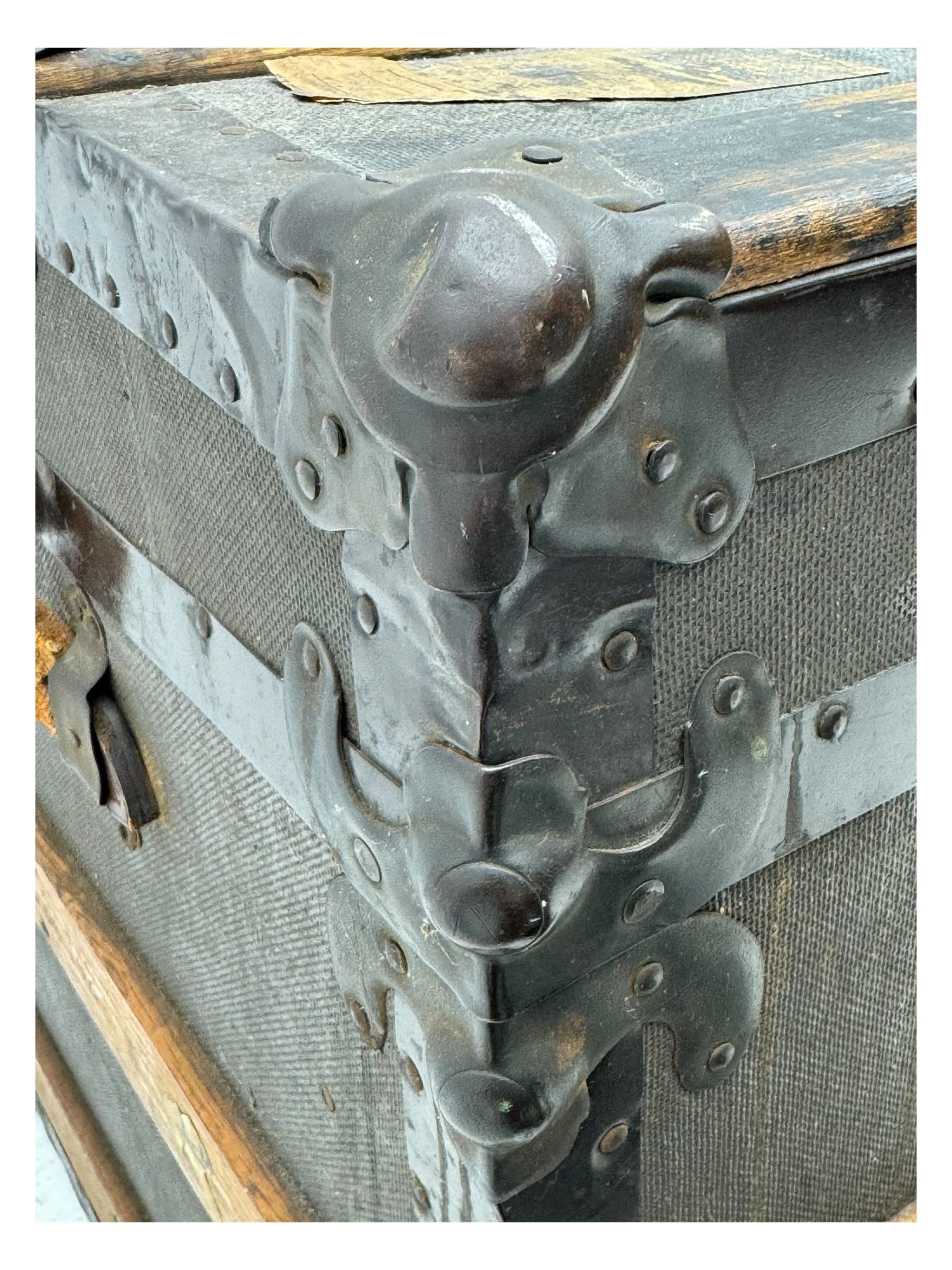 Early 20th century 'McBrine Baggage' steamer trunk, oak frame and black canvas covering, featuring metal hardware and leather straps, fitted with central lock, additional latches, and corner protectors, the interior is lined with floral-patterned paper and includes a removable top tray with makers label 