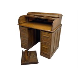 Early 20th century oak twin pedestal desk, tambour roll top enclosing fitted interior, eight drawers, on plinth base