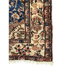 Persian Hamadan ground rug, central medallion design with a salmon pink field, accentuated by navy blue spandrels, surrounded by a stylised floral border in cream and blue tones