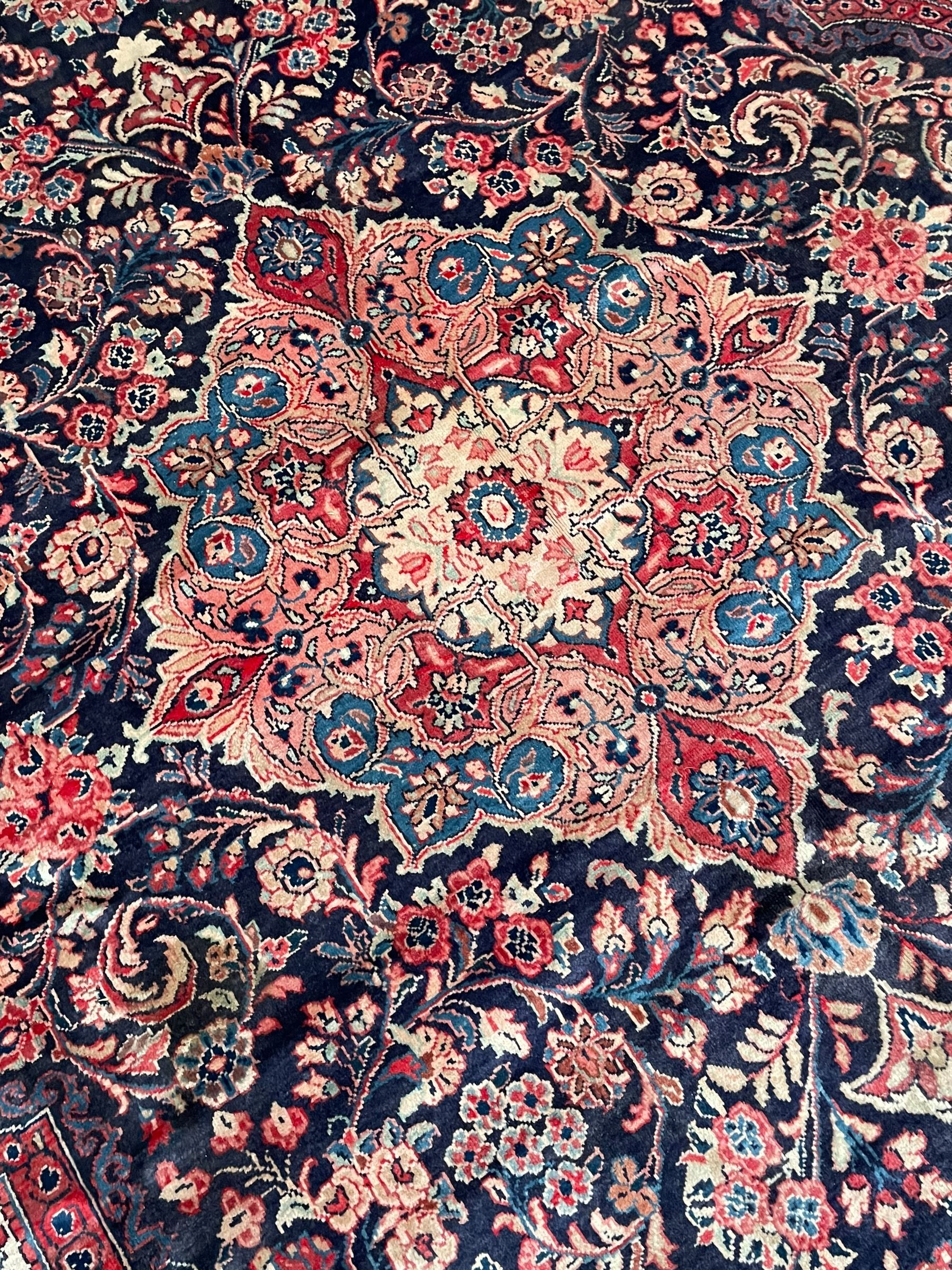 Persian Mahal indigo ground carpet, floral medallion on a field of swirling leafy branches and flower heads, shaped ivory field band decorated with flower head bouquets and trailing branches, the border decorated with floral motifs, within guard stripes