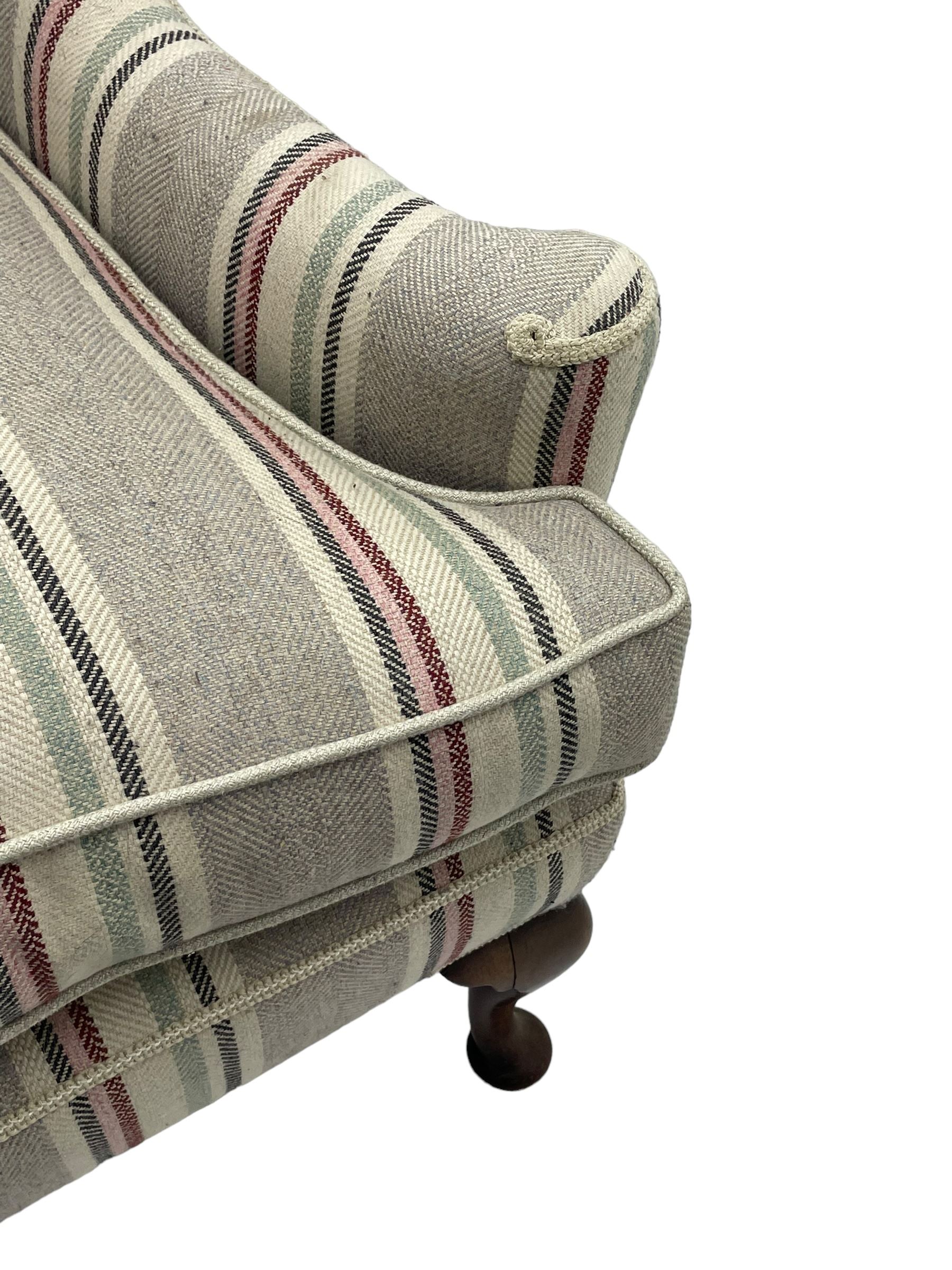 Georgian design hardwood-framed wingback armchair, curved wingback terminating to curved and rolled arms, upholstered in striped fabric with loose seat cushion, on cabriole front feet 