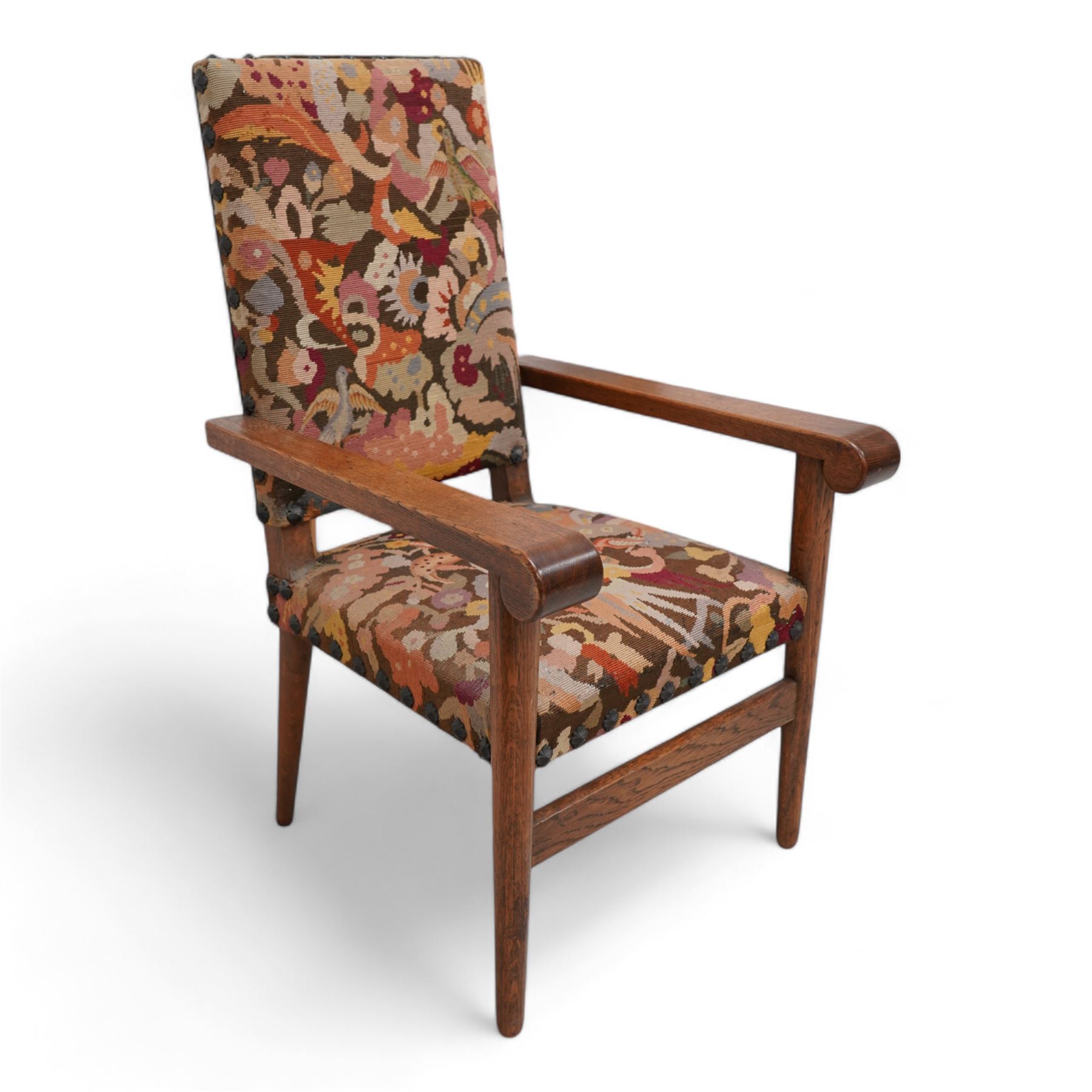 Arts & Crafts period oak framed open armchair, upholstered in needlework cover decorated with stylised floral motifs and birds, projecting arms with rolled terminals, on turned tapering supports united by plain stretcher 