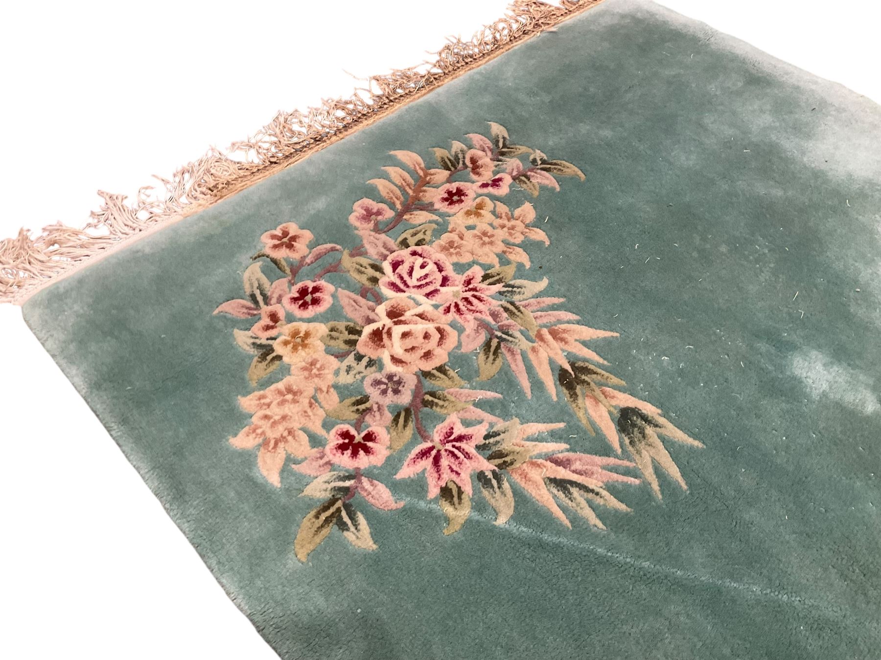 Chinese pale turquoise ground washed woolen rug, the plain field decorated with two large floral bouquet motifs with extending blossom and leafage