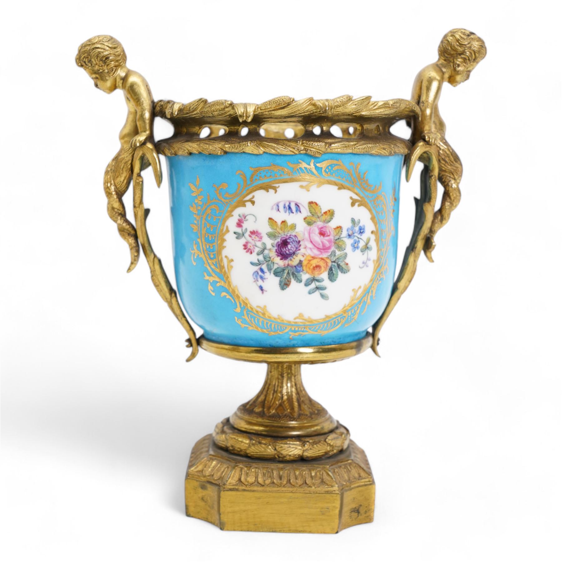 19th century French Sevres style porcelain and gilt brass urn, the body painted with panels of exotic birds and floral sprays within gilt borders on a bleu celeste ground, the handles formed as two cherubs seated upon grasses, upon a laurel leaf cast pedestal base, H20.5cm 