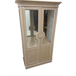 Contemporary display cabinet, moulded cornice above glazed panelled doors with central carved sunburst handles, mirrored back interior with lighting, lower enclosed storage compartment, raised on plinth base