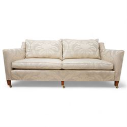 Duresta - Grande hardwood-framed three-seat sofa, upholstered in pale fabric decorated with repeating foliate pattern, on square tapering supports with brass castors 