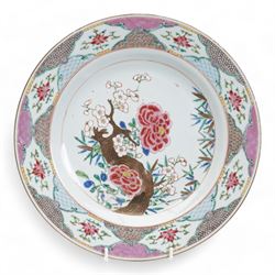 Set of nine Chinese Qianlong famille rose plates, comprising two large circular serving plates centrally enamelled with a blossoming tree branch and bamboo, within a cell diaper border, D32cm and seven side plates with matching decoration, D22.5cm 