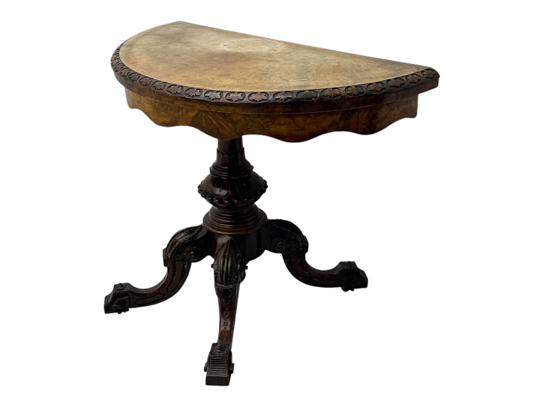 Victorian walnut demi-lune card table, circular fold-over top with foliate carved edge, revealing green baize-lined playing surface over scalloped apron, raised on a turned and carved pedestal with four splayed scroll supports with castors