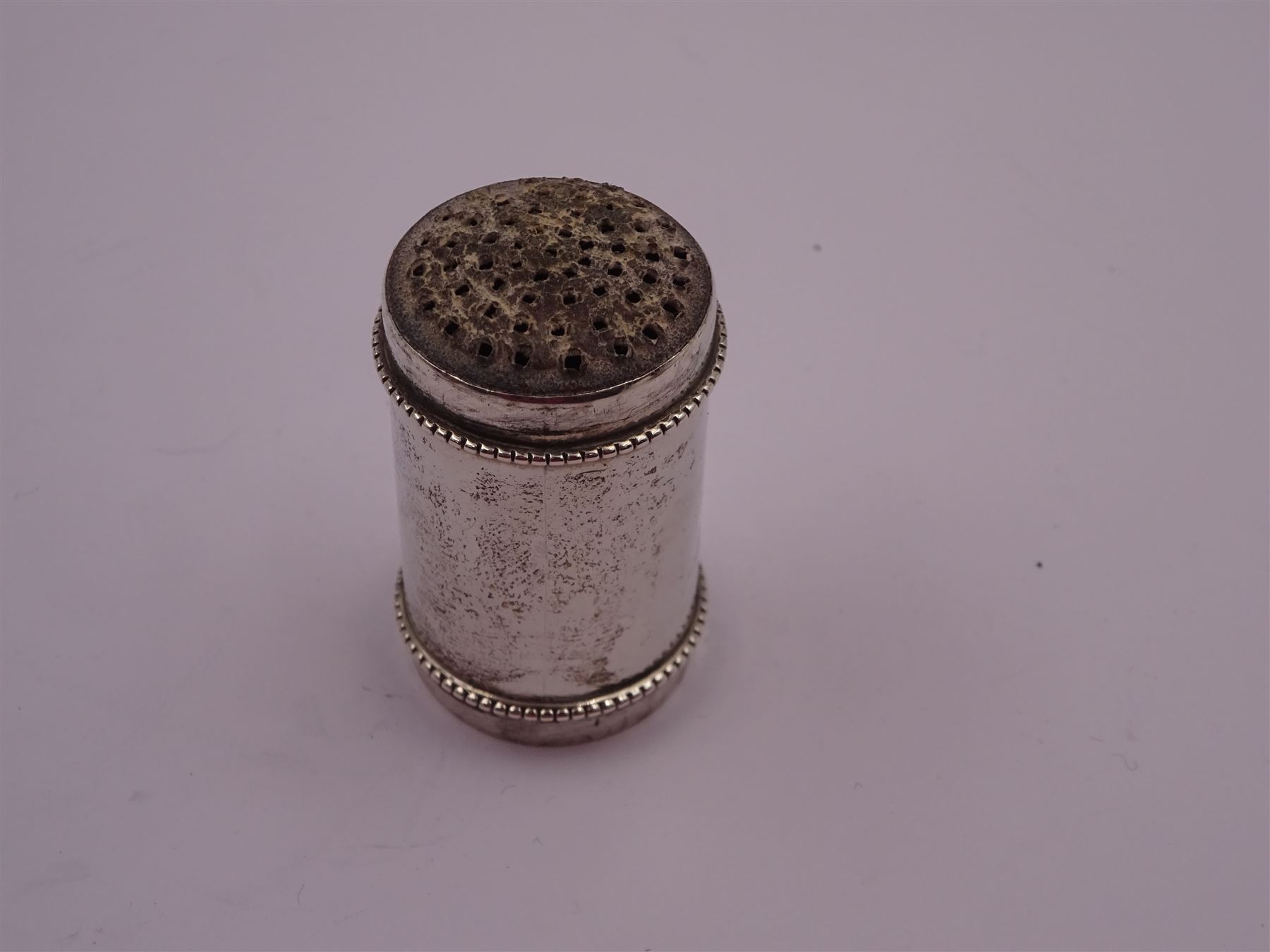 Late 19th century Dutch nutmeg grater, of plain cylindrical form with beaded rim, each end with removable silver covers with a grater to one side, with fish/dolphin mark for below 833 standard, H4.8cm