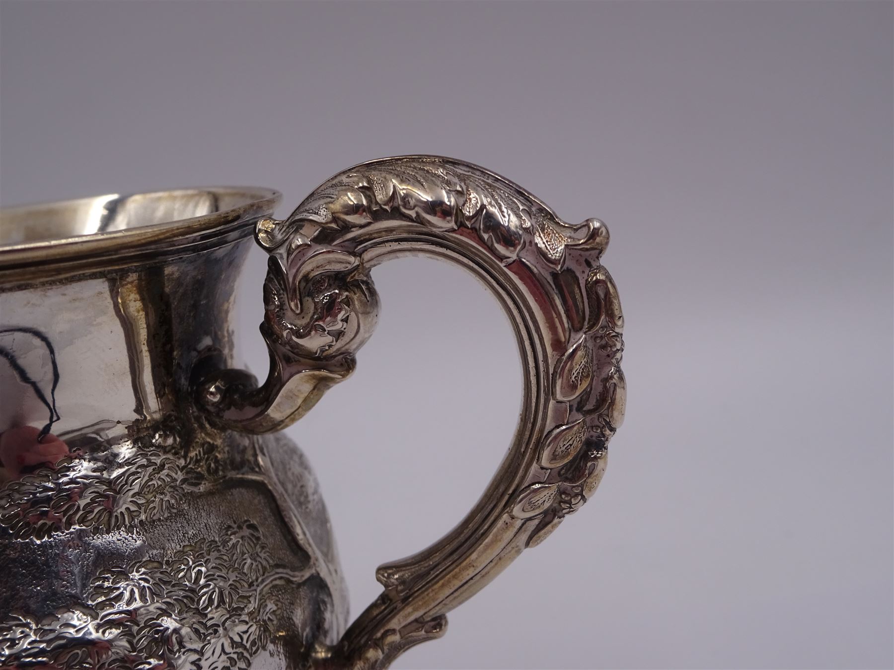 William IV silver christening mug, of waisted form, the body embossed with game birds in a countryside setting and a blank circular cartouche, with acanthus leaf capped scroll handle, upon a circular stepped foot, hallmarked Edward, Edward junior, John & William Barnard, London 1831, H10.2cm