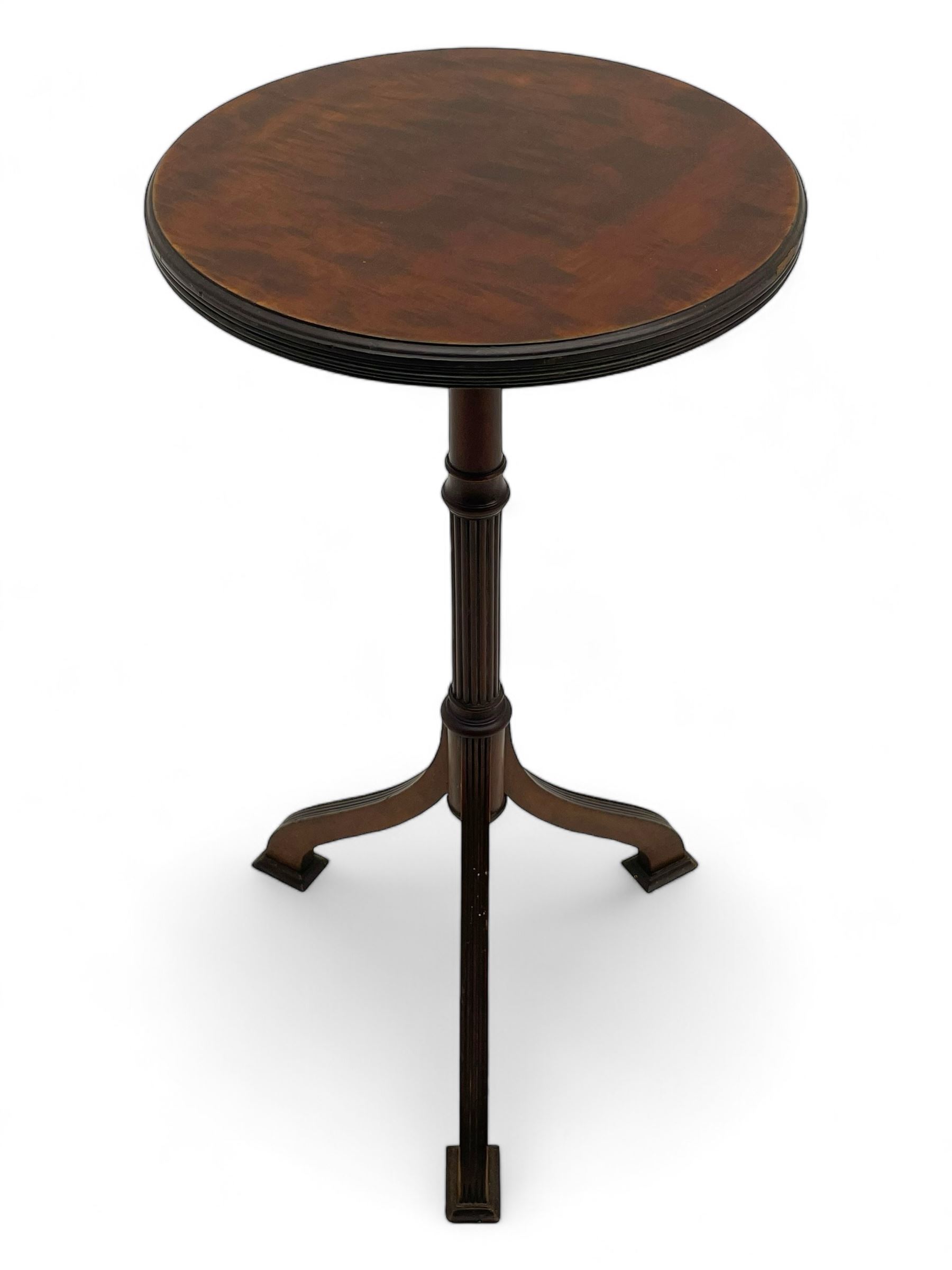 Early 20th century mahogany wine table, figured circular top with reeded edge, on turned and reed moulded stem, three reeded tapered supports on rectangular moulded pad feet 