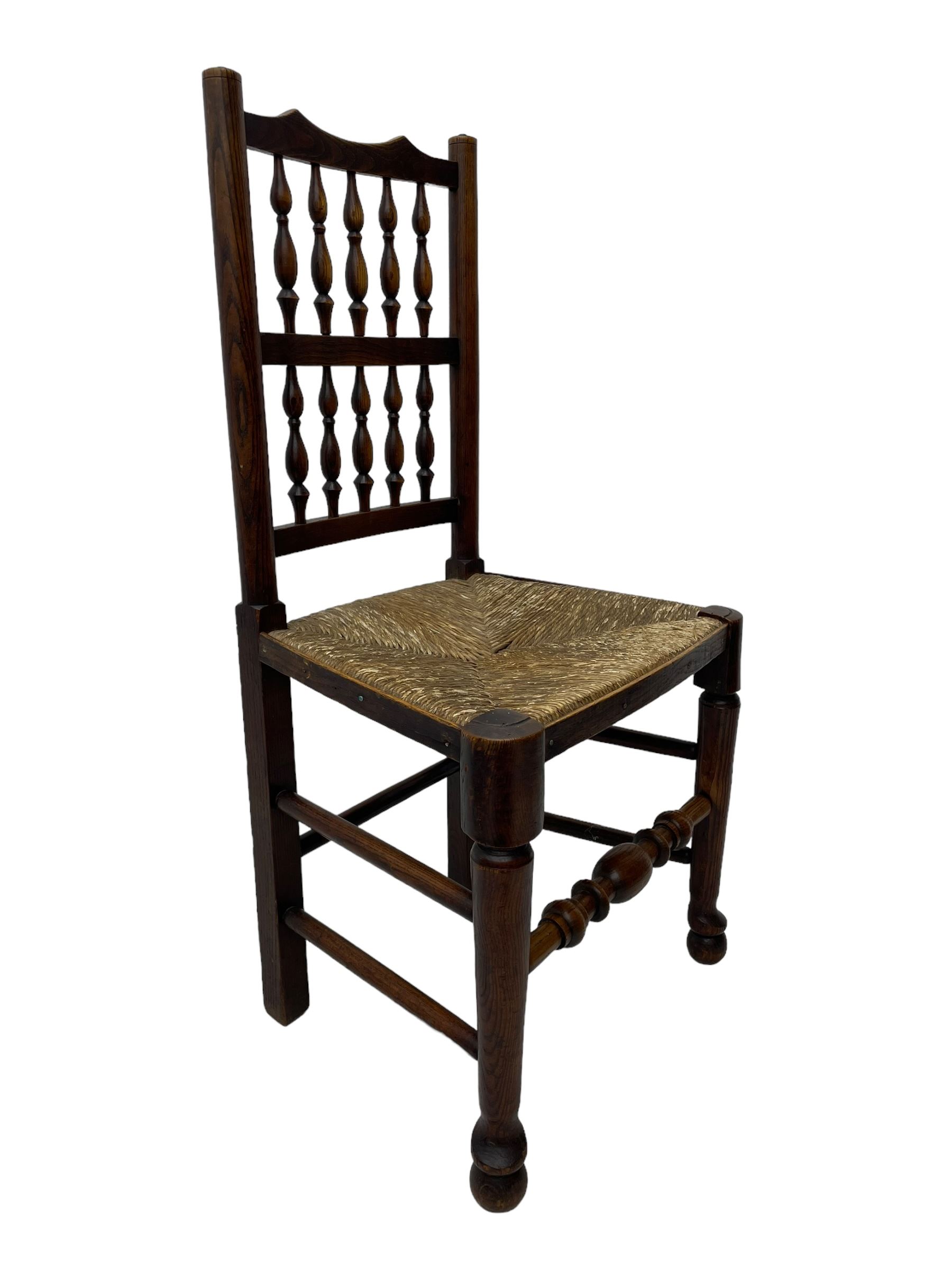 Matched set of twelve 19th century elm Lancashire spindleback dining chairs, shaped cresting rail over spindle back, rush seat, on turned supports united by turned stretchers, ring and globular turned front stretcher 