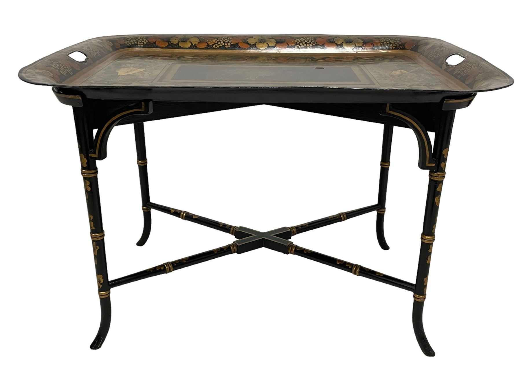 19th century tole ware tray of rectangular form, decorated with Japanese inspired floral motifs and gilt shells, with pierced handles, the associated ebonised and gilt stand, raised on ring turned splayed supports united by X-stretcher, decorated with gilt foliage