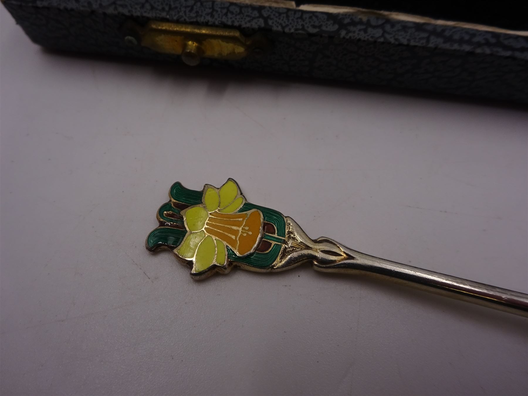 Set of six silver coffee spoons, each with enamelled daffodil decoration to terminal, hallmarked Turner & Simpson Ltd, Birmingham 1938, contained within fitted case