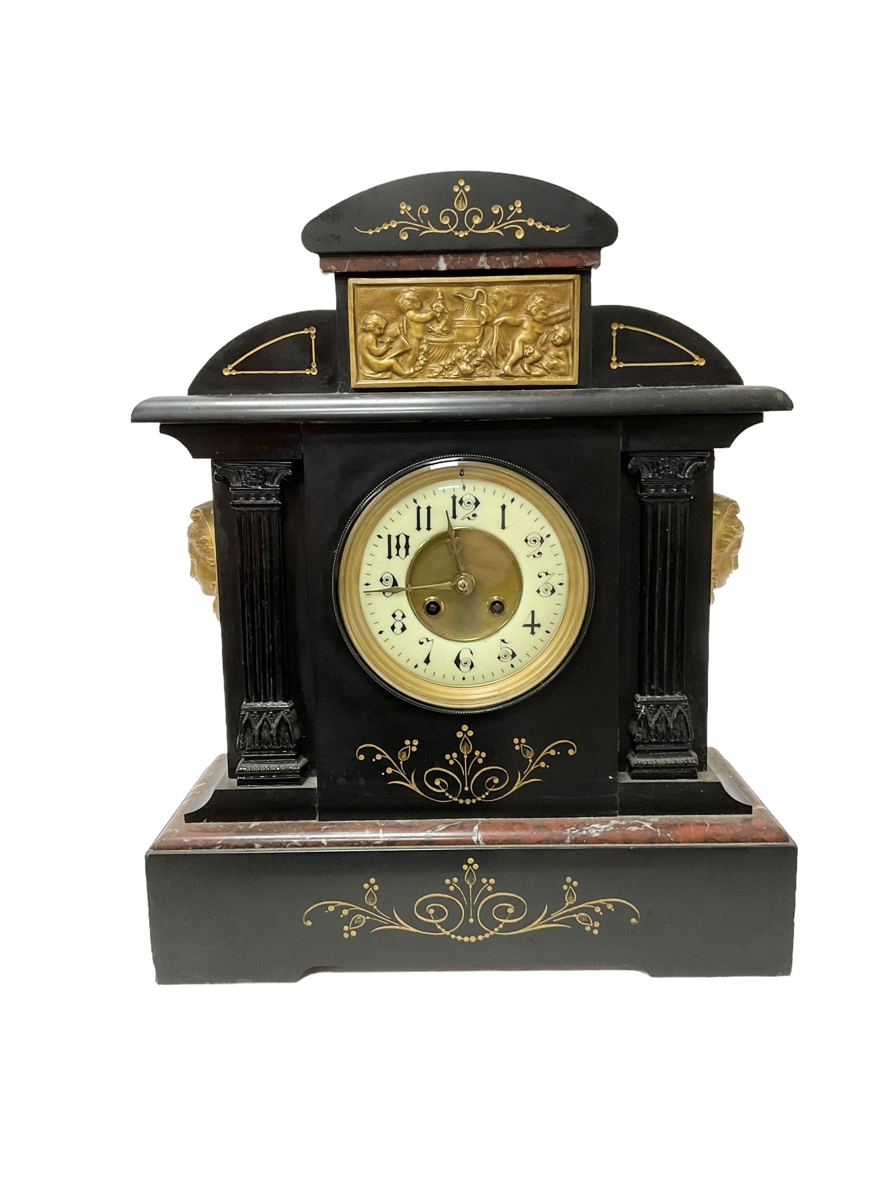 French - late 19th century 8-day Belgium slate mantle clock with incised decoration and contrasting rouge marble inlay, with a gilt repoussé panel to the front and cast cryatid to the sides, two part dial with a gilt centre, Arabic numerals, minute markers and brass fleur di Lis hands, twin train rack striking movement, striking the hours and half hours on a coiled gong. With pendulum. 