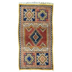 Persian Qashqai crimson ground rug, the field with central indigo and yellow medallion with geometric motifs, flanked by smaller medallions, border with repeating patterns (112cm x 200cm); Turkish Kazak light blue ground rug (109cm x 193cm); red ground runner with three octagonal medallions (69cm x 138cm)