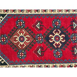 Turkish crimson ground rug, the field decorated with three geometric medallions within a band of star motifs, the main border decorated with stylised plant motifs 