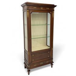 Early 20th century Louis XVI design mahogany vitrine display cabinet, projecting stepped cornice over recessed frieze decorated with gilt metal mounts of festoons and a bellflower wreath, fabric lined interior with two glass shelves, enclosed by bevel glazed door with lower panel, on two turned front feet 