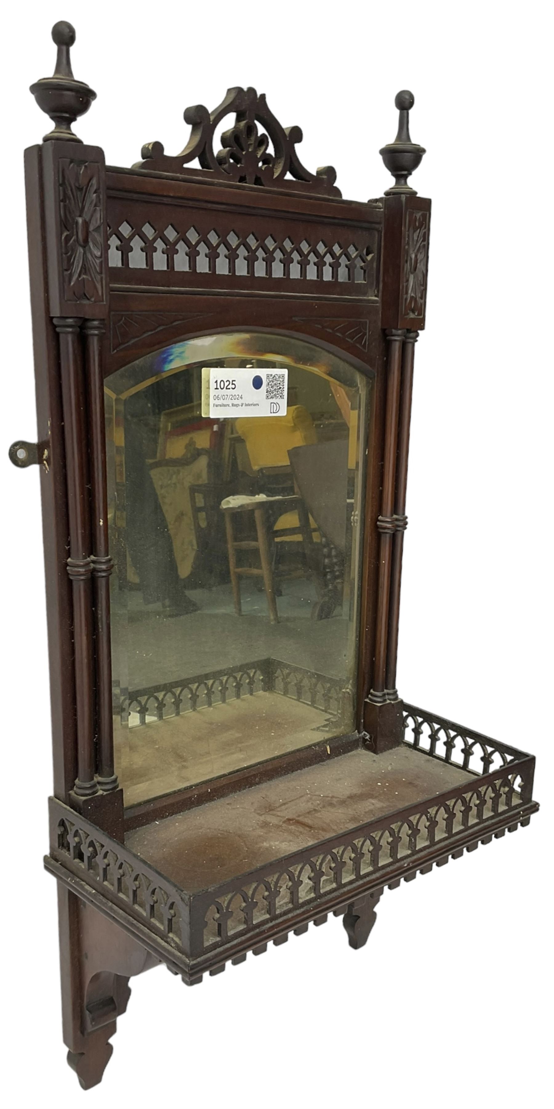 Early 20th century mahogany hall mirror with shelf, pierced pediment flanked by turned finials, the bevelled mirror plate enclosed by turned upright pillars, the shelf with fret work gallery, pierced lattice work lower panel 