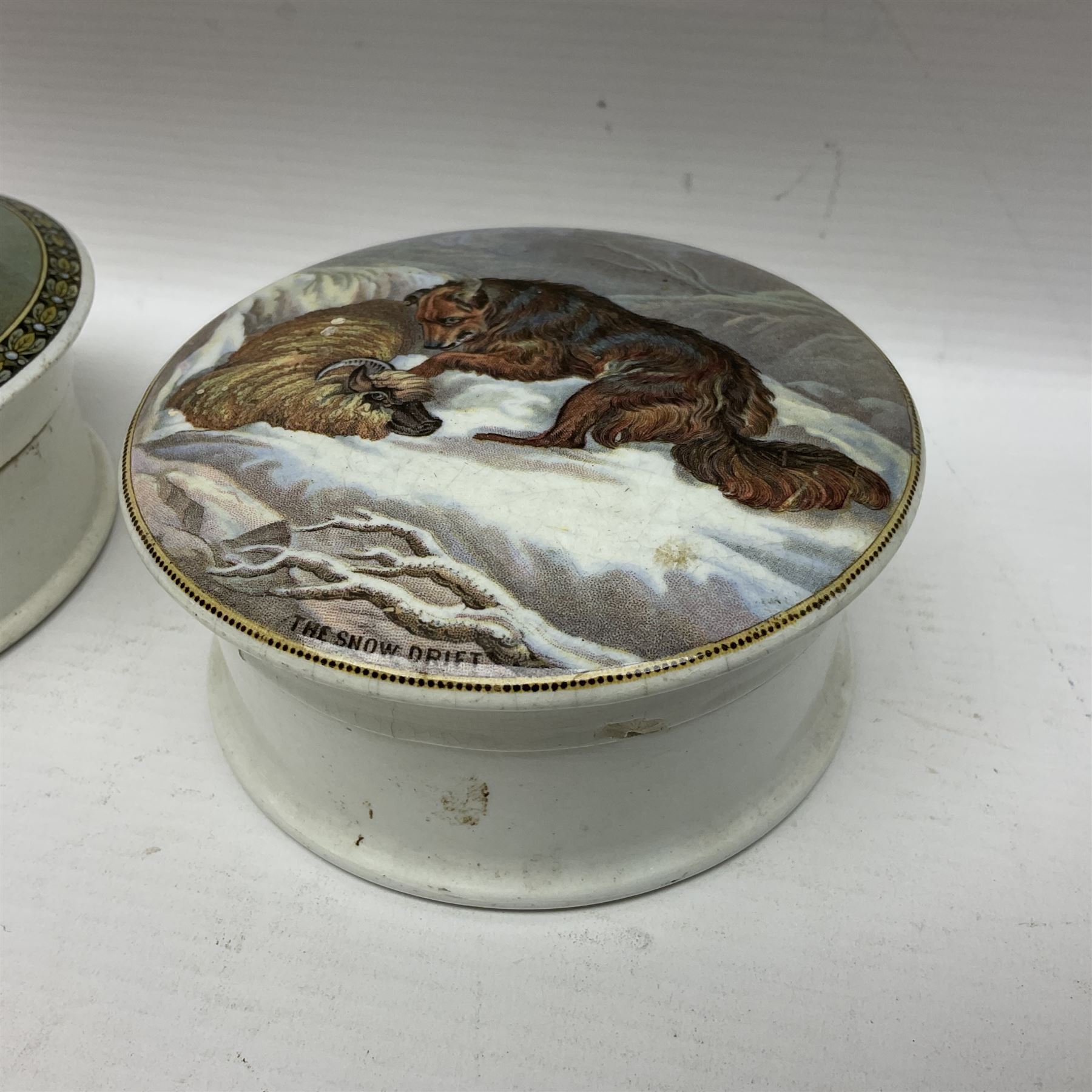 Seven 19th century Prattware pot lids with associated bases, including 'The Snow Drift', 'Strathfieldsaye The Seat of the Duke of Wellington', 'The Late Prince Consort', 'French Street Scene', Lend a Bite', 'Dr Johnson' and 'Sandringham the Seat of HRH The Prince of Wales', largest D12cm (7)