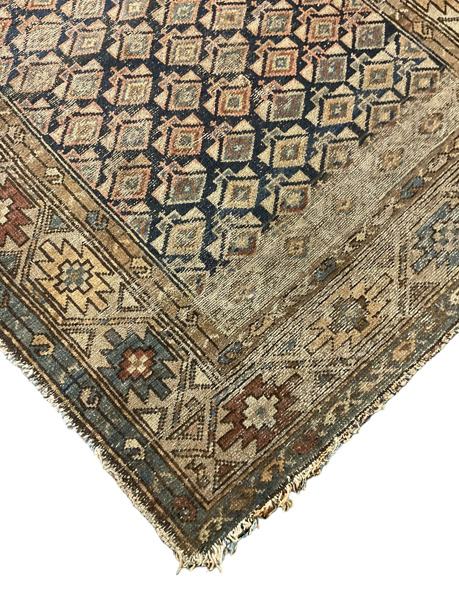 Caucasian indigo ground rug, the field decorated with geometric motifs within geometric pattern borders 