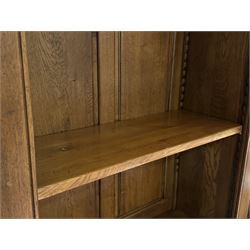 Large 20th century oak dresser, projecting cornice over open arched central section with two shelves, flanked by two panelled cupboards with two shelves, lower section with three drawers above three cupboards, on stile supports 