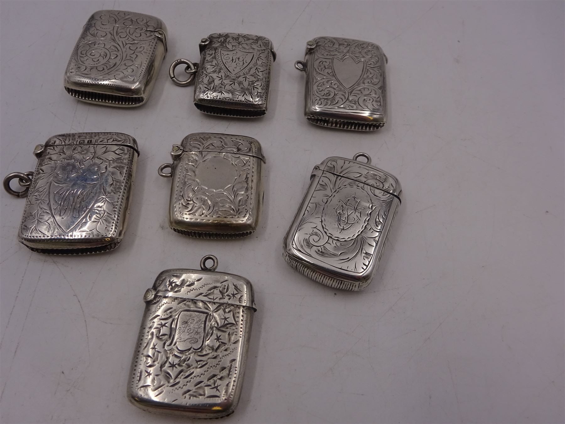 Seven early 20th century silver vesta cases, all of typical form, engraved with foliate and scrolling details, all hallmarked