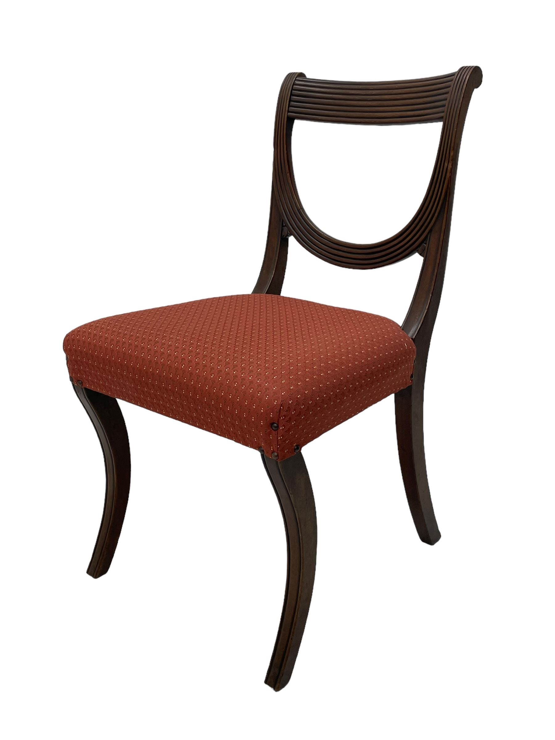 Set of six (4+2) George III design mahogany dining chairs, curved reed moulded bar back over curved and reeded middle rail, upholstered in red fabric with repeating pattern, on moulded sabre supports 