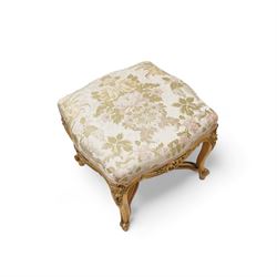 James Shoolbred & Co. (London: 1814-1934) - pair of late 19th century giltwood French design stools, shaped seat upholstered in floral pattern fabric, on shell carved cabriole supports with scrolled terminals, united by shaped X-frame stretchers, with ivorine maker's label inscribed 'Jas Shoolbred & Co.' 