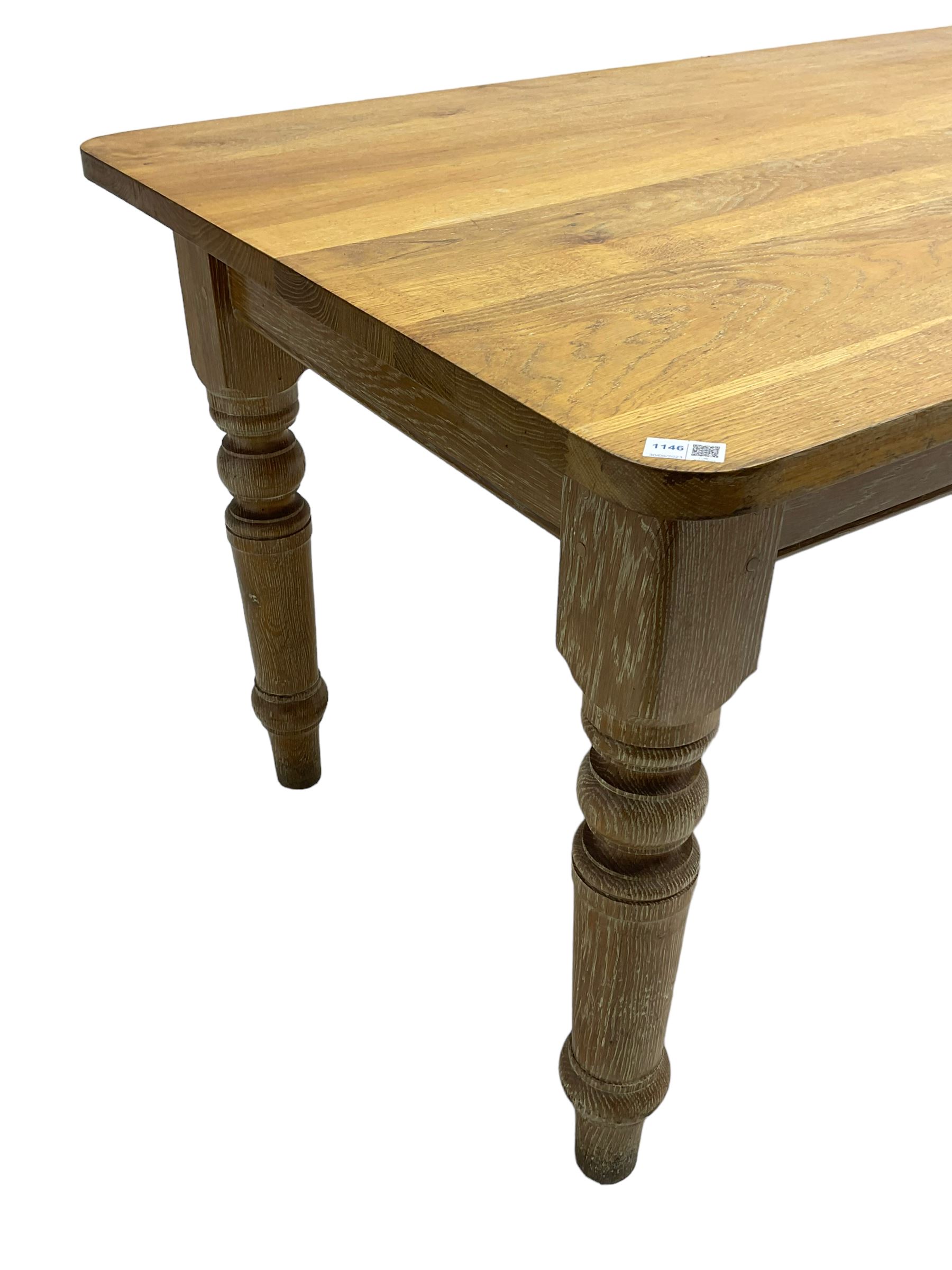 Limed oak dining table, rectangular top with rounded corners, on turned supports