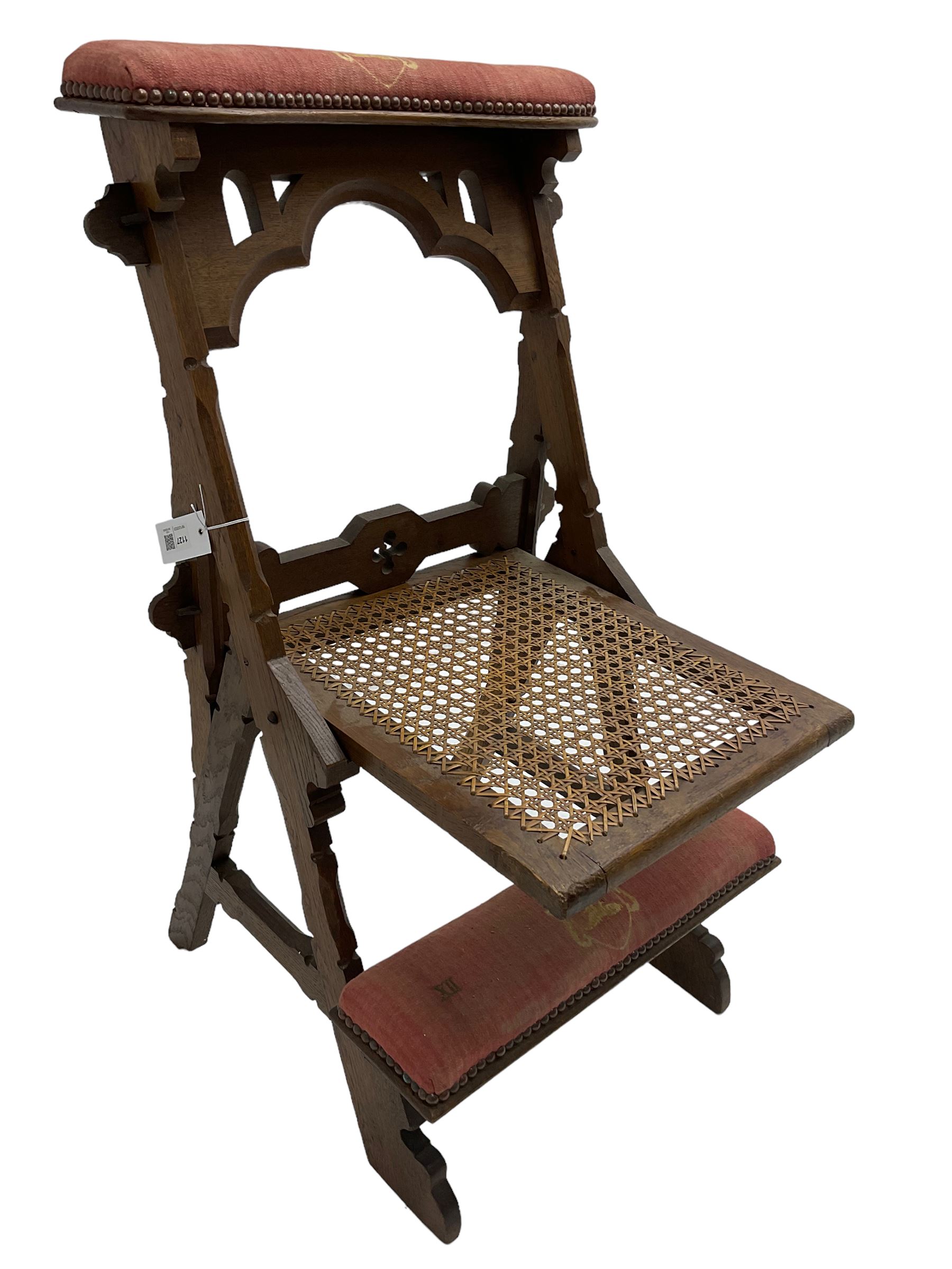 Late Victorian oak metamorphic prie-dieu chair, ecclesiastical design with pegged construction, upholstered kneel rest and top rest, hinged cane work seat