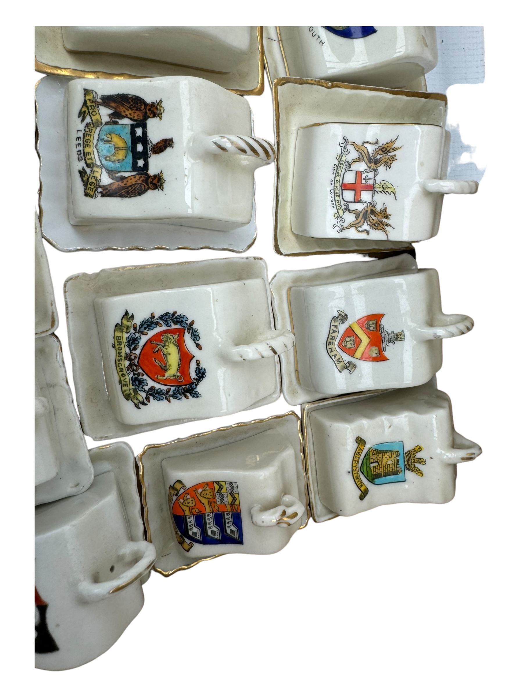 Collection of crested ware miniature cheese dishes and covers, including one by Goss, in one box