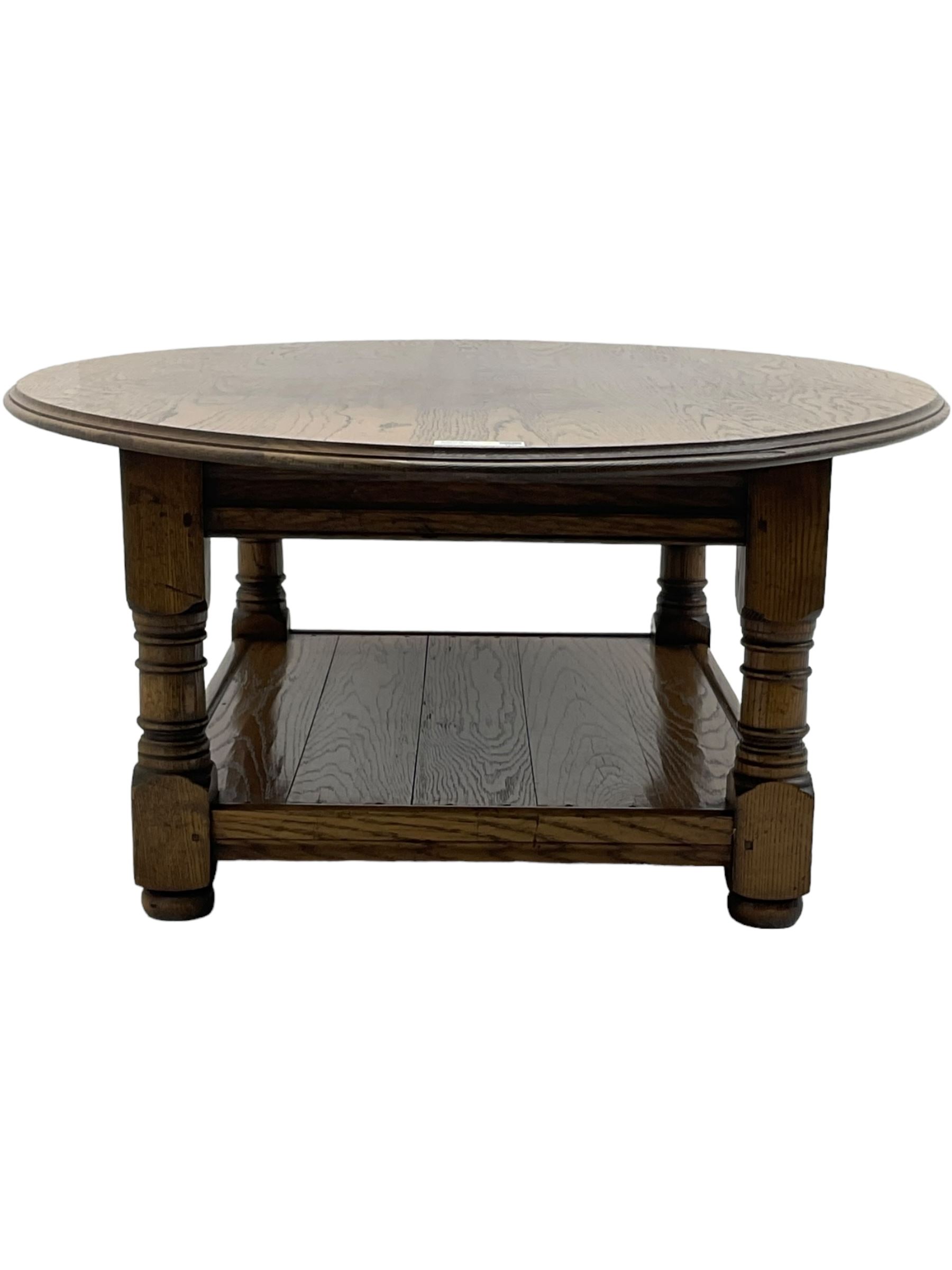 Traditional oak coffee table, moulded oval top, four turned pillar supports united by undertier