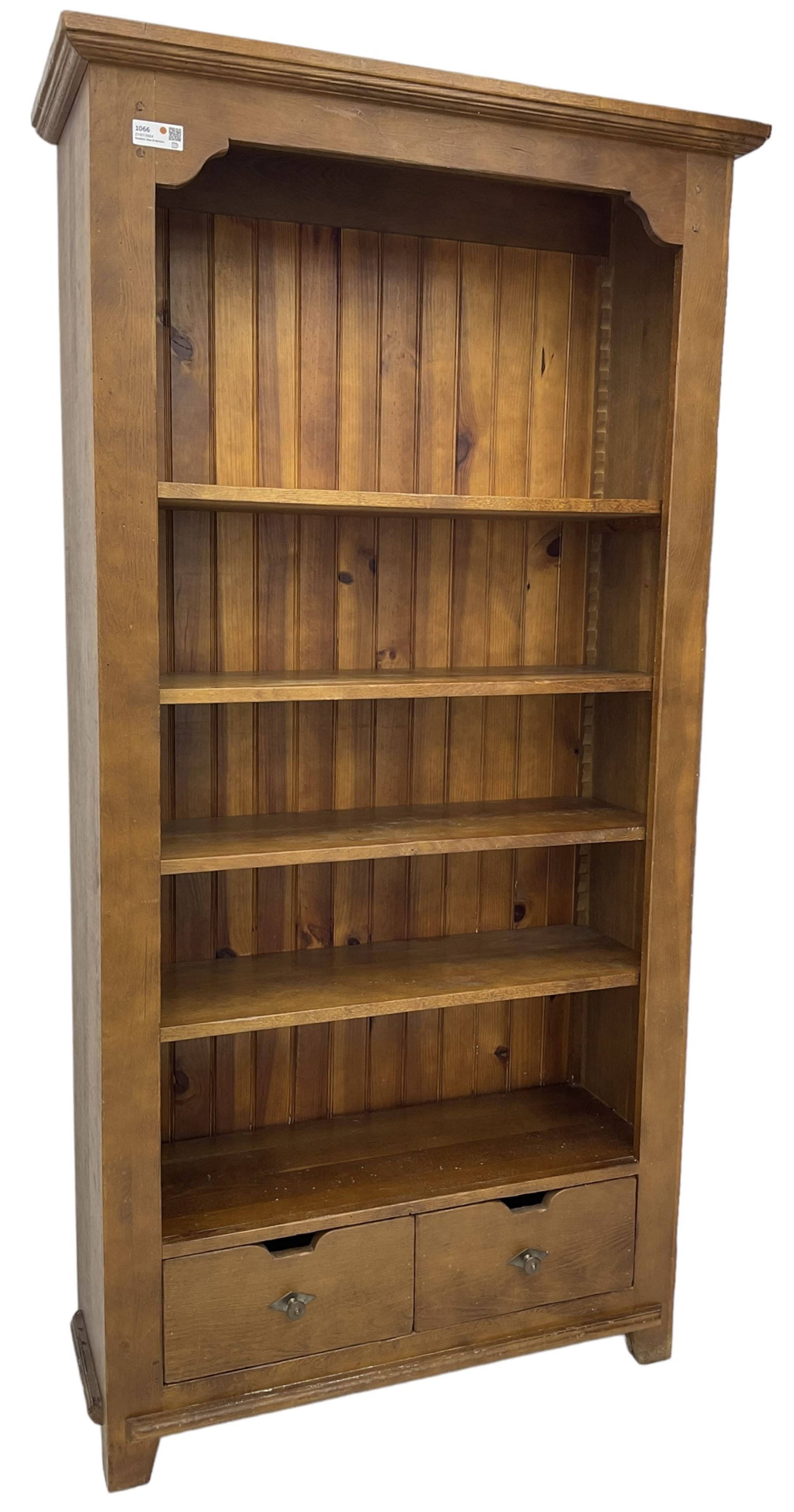 John Lewis - 'Bergerac' oak bookcase, projecting moulded cornice over four adjustable open shelves, two drawers to the base with cut-out handles, on square tapered supports