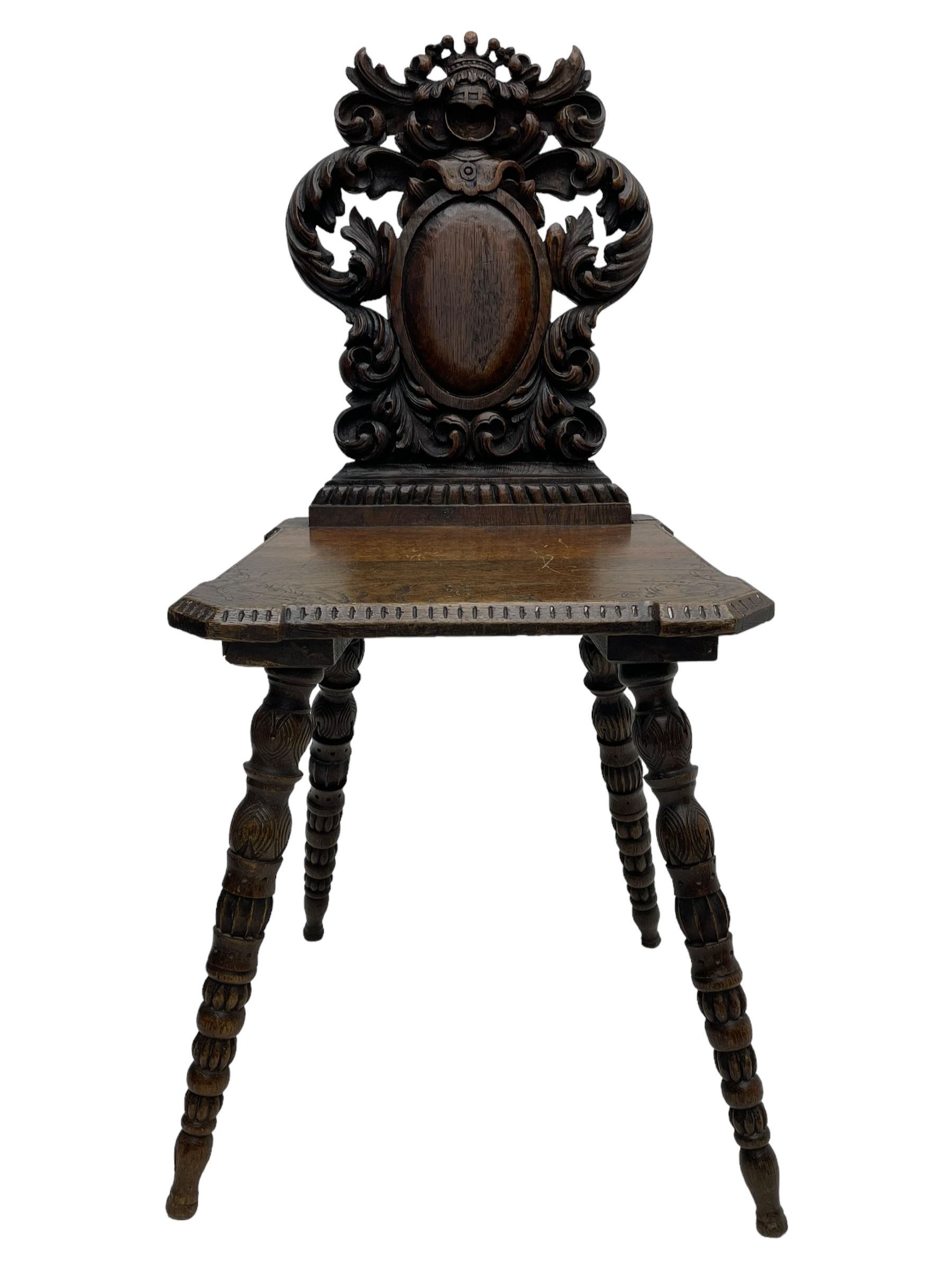 19th century oak hall chair, shaped and pierced back carved with crown cresting over curled and scrolled acanthus leaves, tapered rectangular seat with foliate carved corners and fluted chamfered edge, on turned and lobe carved splayed supports 