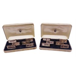 Two sets of six modern silver napkin rings, each of oval form, with Greek key decoration, hallmarked Ari D Norman, London 1986, both in fitted cases