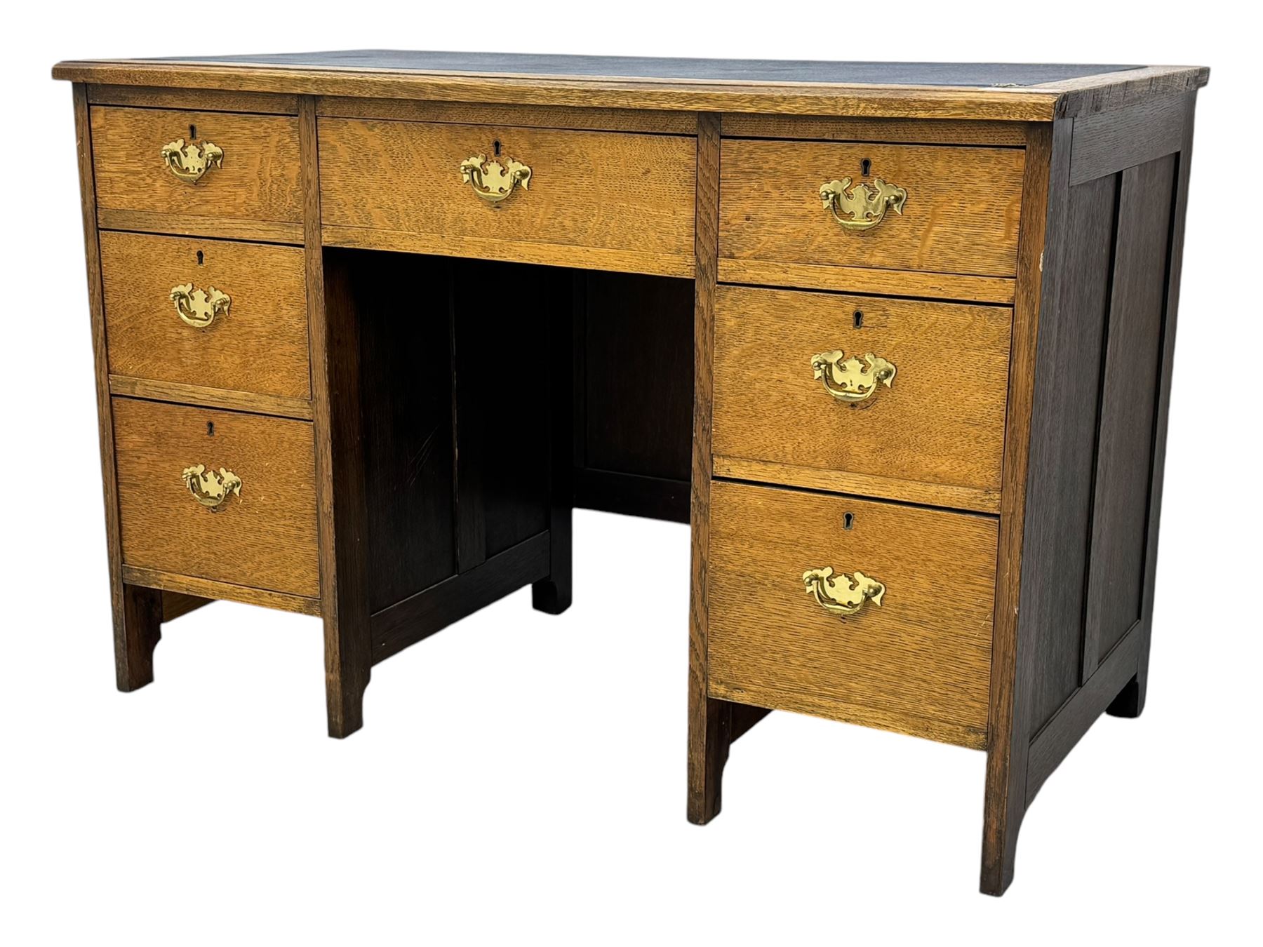 Edwardian oak twin pedestal desk, moulded rectangular top with inset writing surface, fitted with seven drawers, panelled sides, on stile supports 