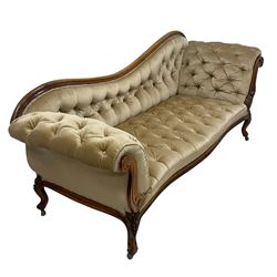 19th century walnut framed chaise longue, shaped back over scrolled arms decorated with moulded curling acanthus carvings, upholstered in deep buttoned champagne fabric, raised on cabriole supports with applied floral carved decoration, on castors