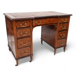 Edwardian inlaid mahogany reverse break bowfront desk, moulded satinwood banded top with inset leather writing surface, fitted with nine drawers, on square tapering feet with brass cups and castors 