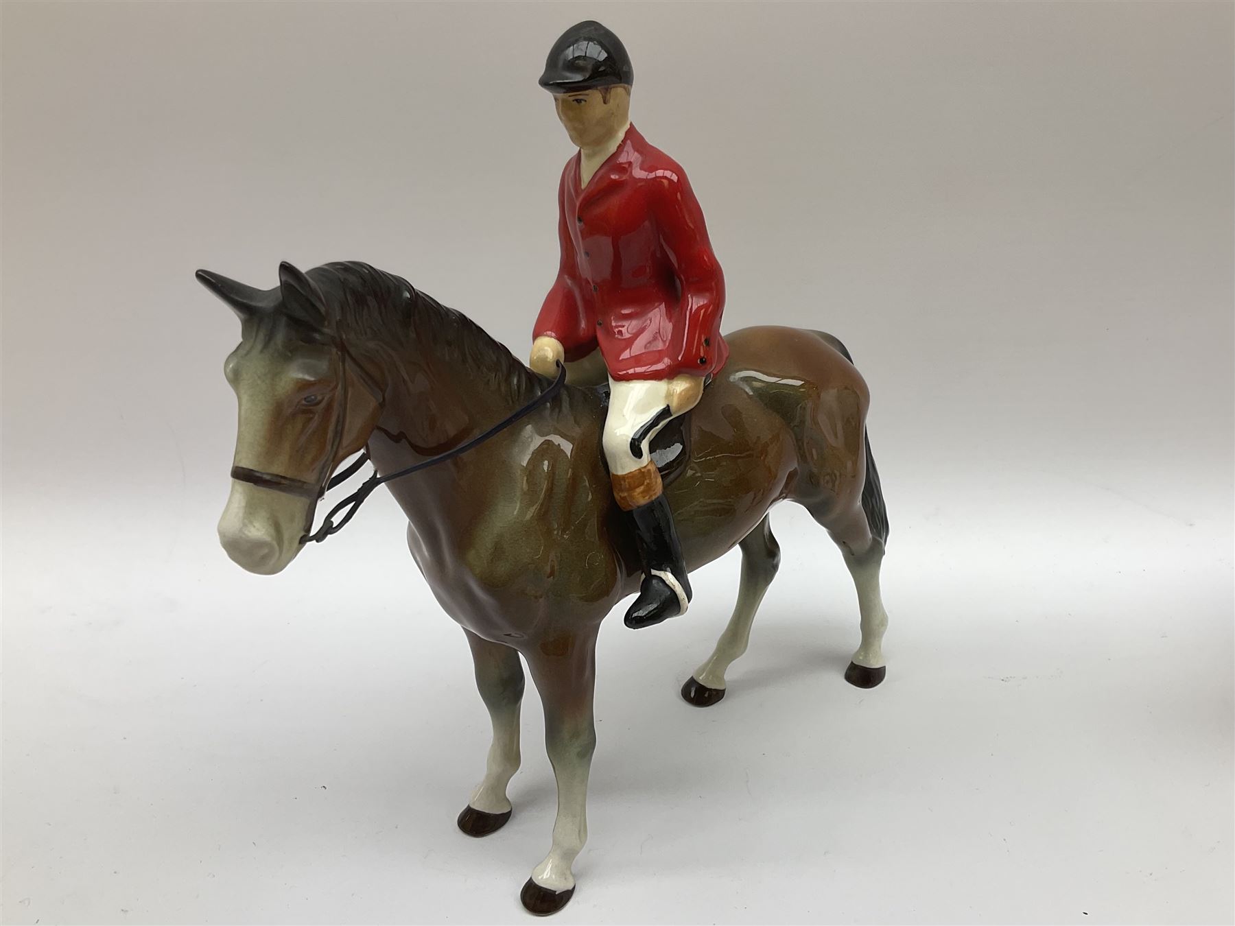 Beswick Hunting Group, comprising: two huntswoman on grey horses, model no 1730, huntsman on a bay horse, model no 1501, a seated fox, model no 1748, eighteen fox hounds and a spaniel, model no 967, all with printed marks beneath, together with three other ceramic huntsman on horseback and two hounds. 