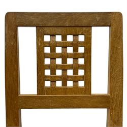 Mouseman - set of six oak dining chairs, pierced and carved lattice panel back over tan leather seat with studded band, on octagonal front supports united by plain H stretchers, carved with mouse signature, by the workshop of Robert Thompson, Kilburn 