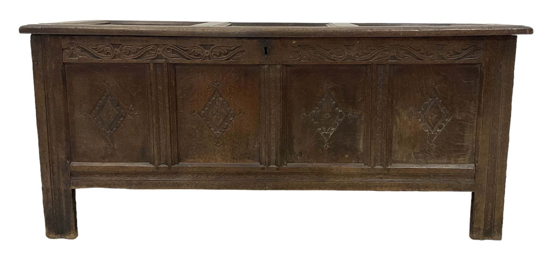 18th century oak coffer or chest, rectangular hinged panelled top with moulded frame enclosing candle box, the frieze carved with foliate S-scrolls over a quadruple panel front decorated with carved lozenges, on stile supports