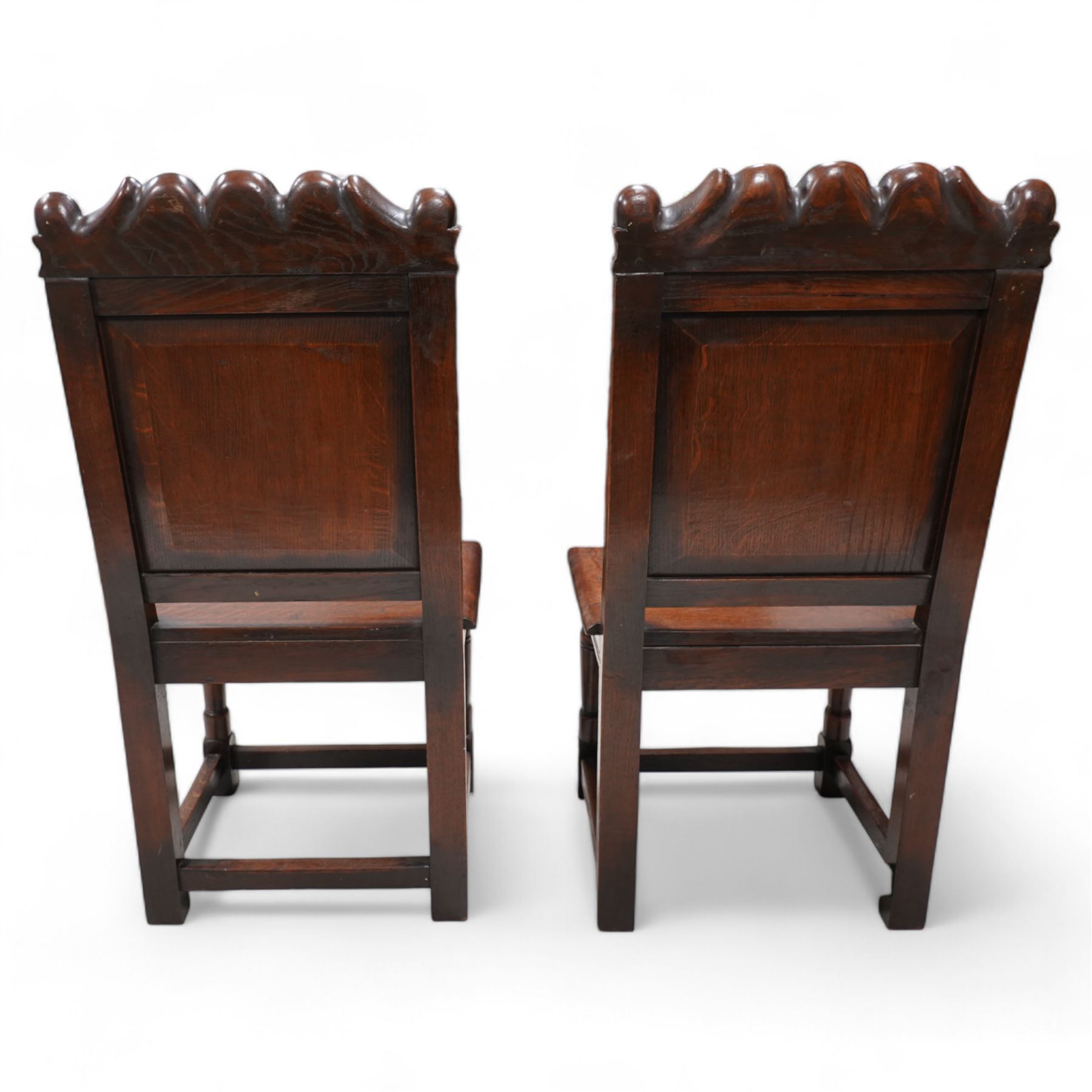 Pair of 19th century Dutch style marquetry oak hall chairs, cresting rail carved with a central green man mask with flanking scrolls, the panelled back inlaid with a bird motif within a guilloche carved arch, panelled seat over scrolling foliate carved apron, on ring turned supports united by box stretcher