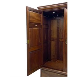 Late Victorian walnut triple wardrobe, projecting moulded cornice over central bevelled mirror door and flanking panelled doors, the top panels carved with fluted fans and stylised leaf motifs, the interior fitted with three linen slides, two drawers and hanging space, two long drawers to base, reed moulded uprights and vertical fluted horizontal rails 