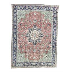 Persian rose ground rug, large central floral medallion surrounded by scrolling foliate and floral motifs, pale green spandrels, wide border in pale green and navy with intricate floral designs, framed by multiple guard stripes with repeating floral and geometric patterns