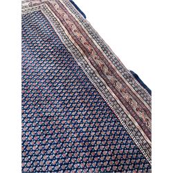 Large North-West Persian Arrak indigo ground carpet, the field decorated all-over with small Boteh motifs, multiple band border decorated with repeating geometric designs