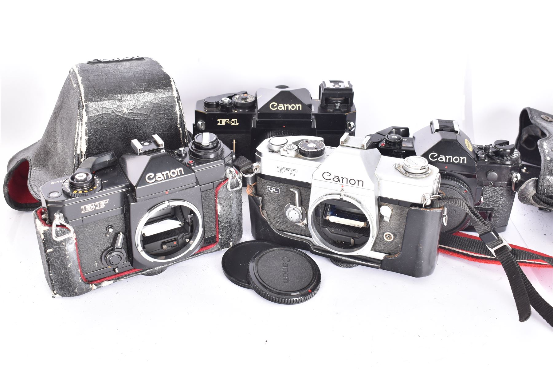 Four Canon SLR camera bodies, to include F-1 serial no. 273243, A-1 serial no. 1818620, EF serial no. 317419, all in black finish, with Canon cases, and an FT serial no. 251226 in black and silver finish