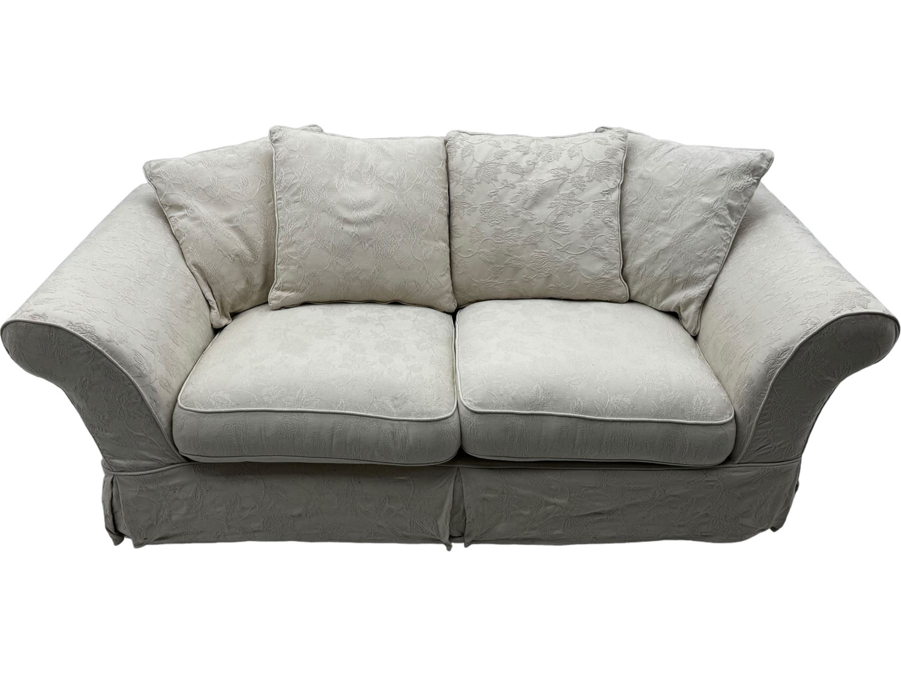 Two-seat traditionally shaped sofa, upholstered in pale floral pattern fabric, with additional covers